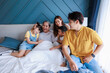 © NVB Stocker - Happy family, Parent and children visit grandmom in bedroom, sitting together on bed, hug, smile at home.