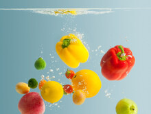 Fresh Fruits And Vegetables Falling Into Water With Air Bubbles On Blue Background.