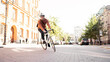 © muse studio - A cyclist in a helmet goes to work with a briefcase. Urban ecotransport.  Fitness watch on hand.