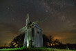 The ghost of the old mill. Old windmill at night with starry sky.