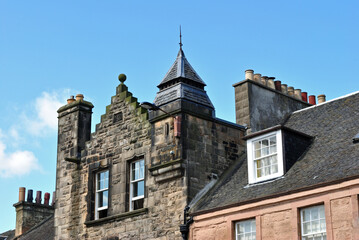 Wall Mural - Old Stone Building with Chimneys seen against Blue Sky 