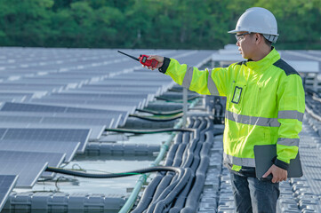 Asian engineer working at Floating solar power plant,Renewable energy,Technician and investor solar panels checking the panels at solar energy installation