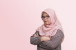 © Yazid Nasuha - Portrait of confident Asian businesswoman with hijab, keeping arms crossed. Isolated image on pink background