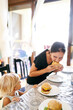 © Oleksandra - Little girl watches her mother eat a hamburger at the table. High quality photo