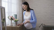 © PRPicturesProduction - waist up japanese expectant mother propping herself on the cabinet is suffering labor contraction with a painful expression at home.