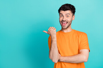 Canvas Print - Photo of young handsome bearded funny positive guy smile excited finger pointing empty space advertisement crazy isolated on aquamarine color background