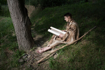 Man sitting on the grass and reading book