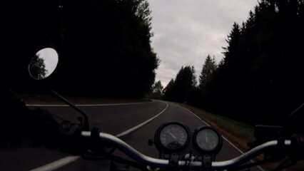 Wall Mural - retro motorcycle on an asphalt forest road on a cloudy day in autumn. Dramatic trip.	