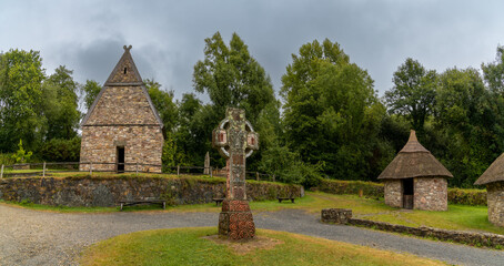 Sticker - view of an early reconstructed Christian monastery in the Irish National Heritage Park with a large Celtic cross in the foreground