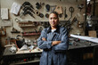 © Seventyfour - Waist up portrait of multiethnic female worker posing in workshop with arms crossed and looking at camera, copy space