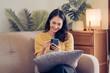 © Kritdanai - Young Asian woman relax on cozy sofa furniture in living room using browsing Internet on tablet, Asian girl lying resting on comfortable couch at home watching movie or video on pad.
