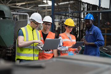 Group of factory worker working with computer laptop in factory. Male and female worker discussing and training about work at factory.