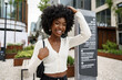 Leinwandbild Motiv Portrait of young african woman with hairstyle smiling in urban background