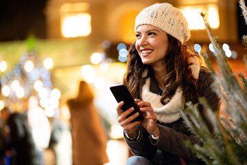 Festive christmas fair concept. Happy smiling woman having fun and shopping on the christmas market.