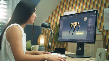 Poster - Asian woman working on pc in 3D modeling program remotely from home office and creating 3D prototype of modern robot