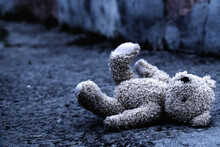Teddy Bear Toy Forgotten On The Street As Symbol Of Children's Loneliness, Pain, Broken Childhood And Loss Future. Copy Space For Text Or Design.