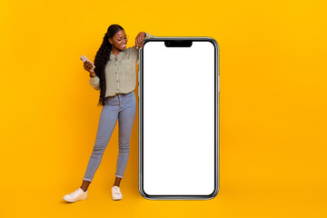 full body portrait of pretty positive person look empty space huge phone isolated on yellow color ba