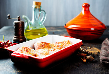 Wall Mural - Raw uncooked chicken legs, drumsticks in bowl, meat with ingredients for cooking