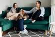 © Татьяна Волкова - Two tranquil and satisfied women and little boy sit on sofa, stroking dog Cavalier King Charles spaniel in living room