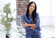 © ASDF - Attractive young businesswoman standing near desk in the office