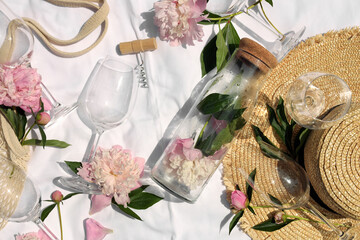 Wall Mural - Flat lay composition with beautiful peonies and wineglasses on white fabric