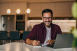 © bnenin - Portrait of a smiling man, working from the home office while writing notes.