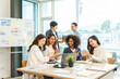 © makibestphoto - Young and successful mixed race, asian business people working on project together, sitting at table in boardroom.