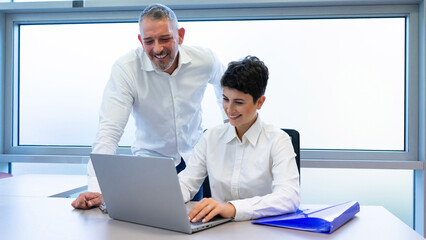 Businessman and businesswoman work on laptop in office .  Caucasian couple smiling while talking business sitting desk , work concept . clear background 
