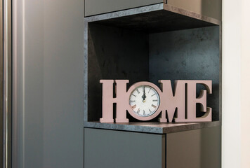 A shelf in a gray cabinet with a decorative insert in the form of four-dimensional letters 