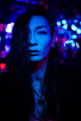 Portrait of a transgender model in a studio with neon lighting.