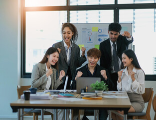 Young happy Asian business man, woman work together, celebrate success in start up office. Creative team brainstorm meeting, businesspeople colleague partnership or office coworker teamwork concept