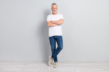 Wall Mural - Full size photo of nice elder man crossed arms wear t-shirt jeans sneakers isolated on grey color background