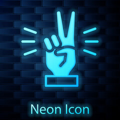 Wall Mural - Glowing neon Hand showing two finger icon isolated on brick wall background. Victory hand sign. Vector