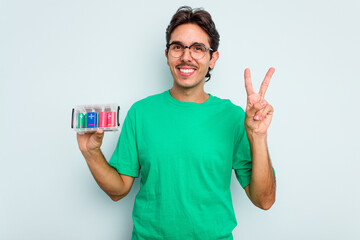 Young hispanic man holding battery box isolated on white background showing number two with fingers.