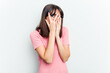 © Asier - Young caucasian woman isolated on white background blink through fingers frightened and nervous.