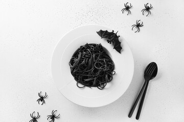 Wall Mural - Halloween alternative creative Italian black pasta squid ink decorated funny spiders and bat on white background. View from above. Food concept.