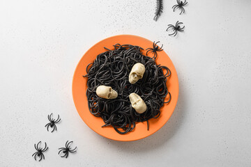 Wall Mural - Halloween alternative creative Italian black pasta squid ink decorated funny spiders in orange plate on white background. View from above. Food concept.