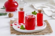 Homemade Red Berry Juice, Shrub Or Syrup In Small Glass Bottles With Paper Straws On White Background