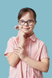 © Seventyfour - Vertical portrait of cute girl with Down syndrome holding flower against blue background in studio