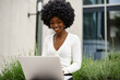 © fotofabrika - Young african american businesswoman working using laptop sitting on the bench in the city