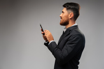 Wall Mural - Young businessman using mobile phone in studio