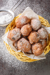 Dutch Oliebollen Oil Balls are also sometimes called Dutch Donuts or Dutch Dough Balls closeup in the basket on the table. Vertical top view from above