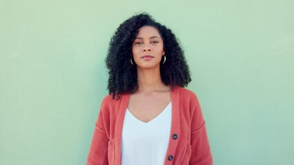 Wall Mural - Black woman, confident beauty and young model pose for portrait with afro hair on green background. African girl in orange sweater, fold arms with cool serious face and casual fashion lifestyle