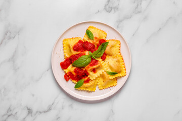 Delicious appetizing ravioli with tomato sauce and basil