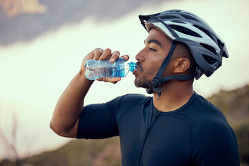 Wall Mural - Fitness man, cycling and drinking water bottle and wearing safety helmet outdoors in nature during summer. Male athlete, exercise and hydration riding a bike to practice, workout or train for sports