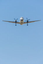 Looking Up At An Aeroplane With Propellers Spinning Against A Blue Sky