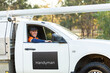 © Austockphoto - Happy man driving his ute working for himself as handyman in country