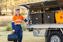 Happy Male Handyman With Toolbox Bag Laughing Near Tradie Ute