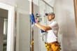 © Angelov - Plumber installing shower stall, work in bathroom.