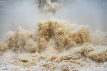 Close Up Of Gushing Water Spraying Out From Over Full Dam.